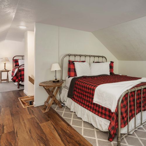 A cozy hotel-style hallway with a bright lobby, wooden accents, and a red upholstered seating area.