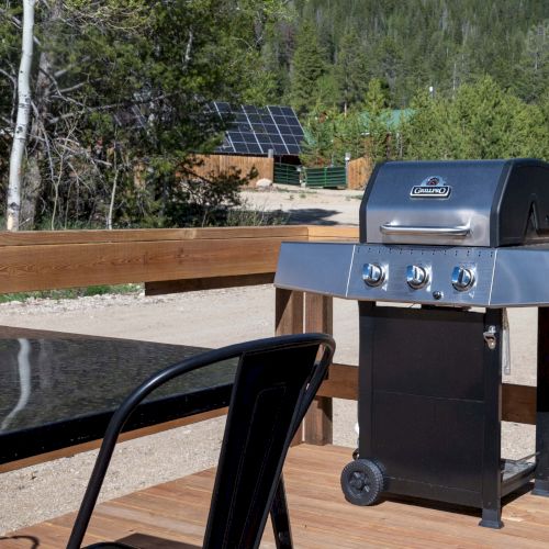 A car on a road behind a fenced barrier, with a speed camera or sign ahead on the right, sunset lighting and trees in the distance.