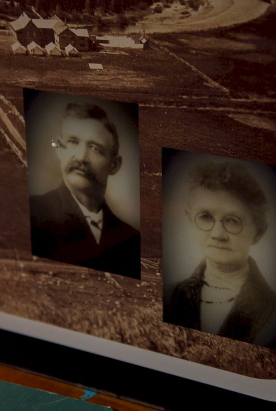 Pictures of two vintage portraits on a wooden sign, with text on the left; a curved white edge frames the scene at the bottom right.